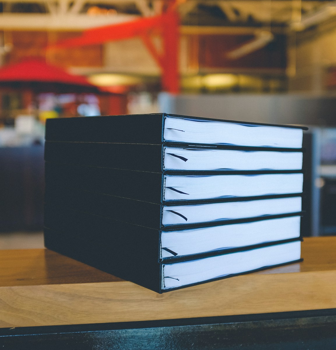 six black books on top of brown wooden table